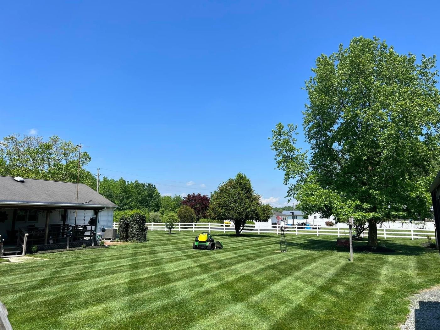 Zero-turn mower working an open field with fresh stripes