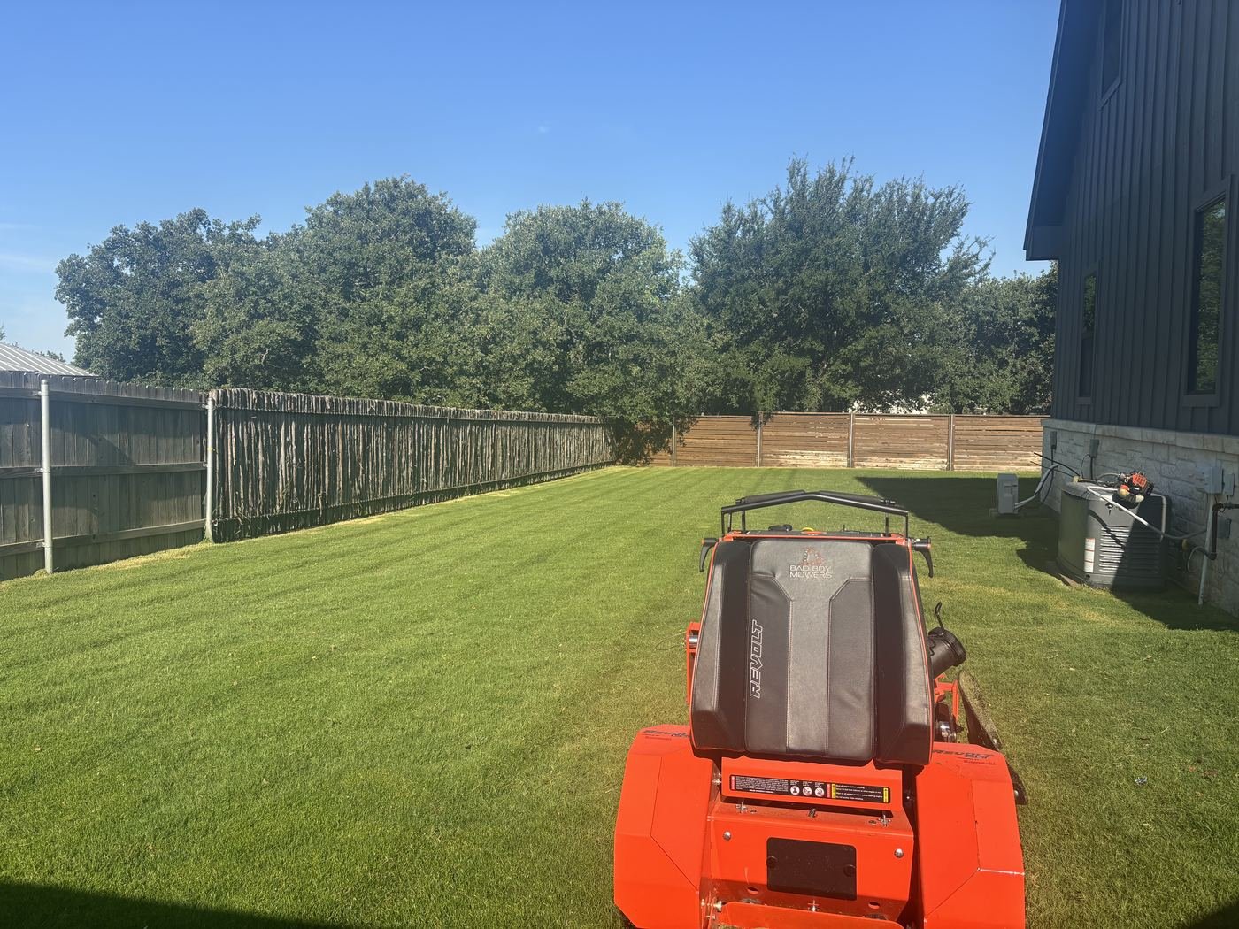 Bad Boy mower working a fenced backyard